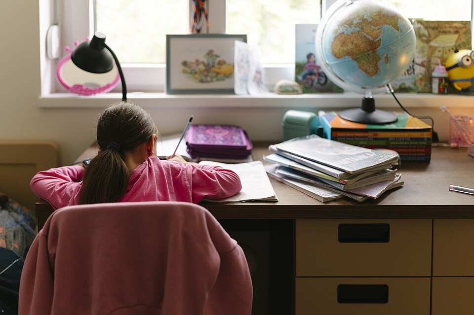 窓辺の机で勉強する人の後ろ姿